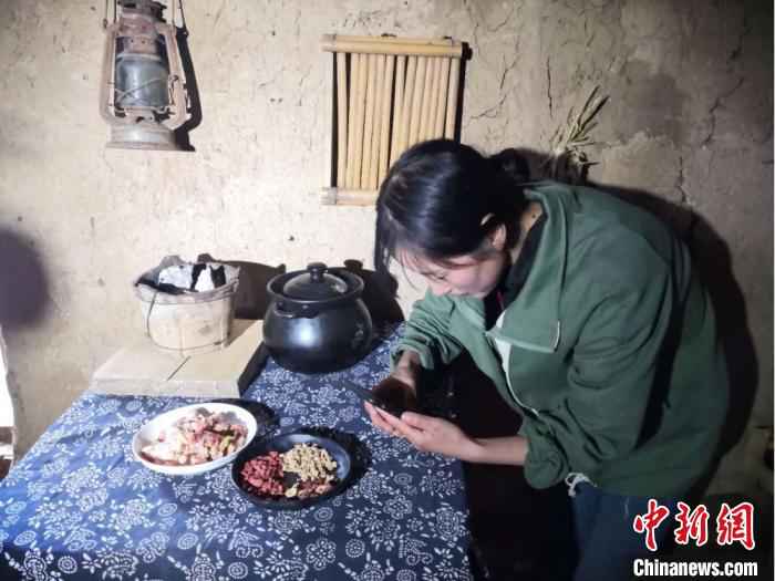 图为宕昌磨河坝村农家女，用手机录制烹饪“山味”的视频，与生活在都市的网友们分享。　后孝贤 摄